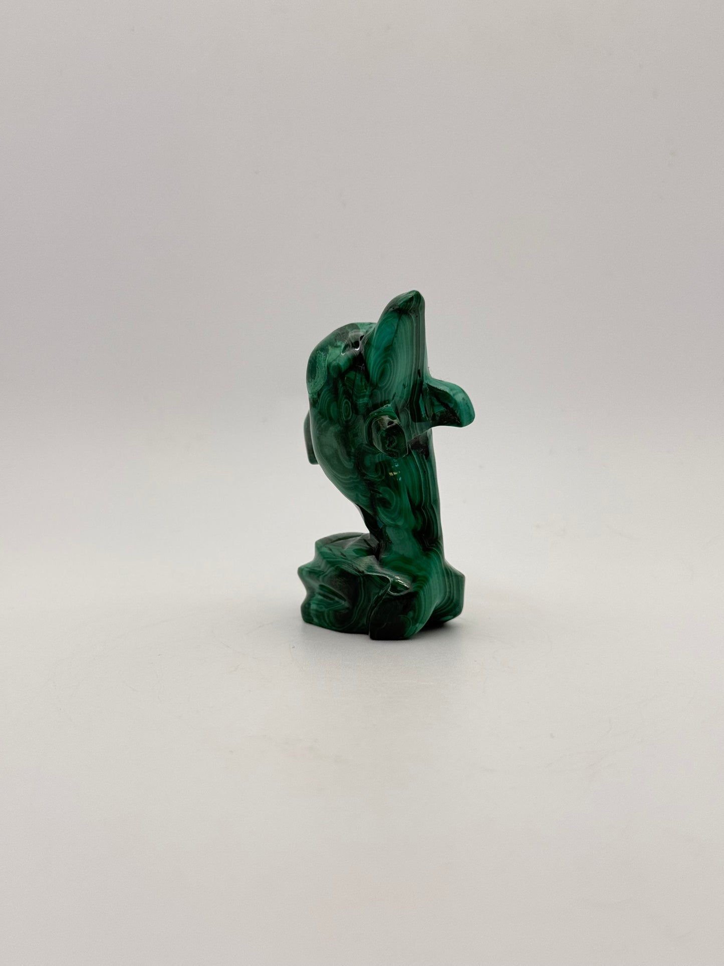 Polished malachite dolphin carving.
