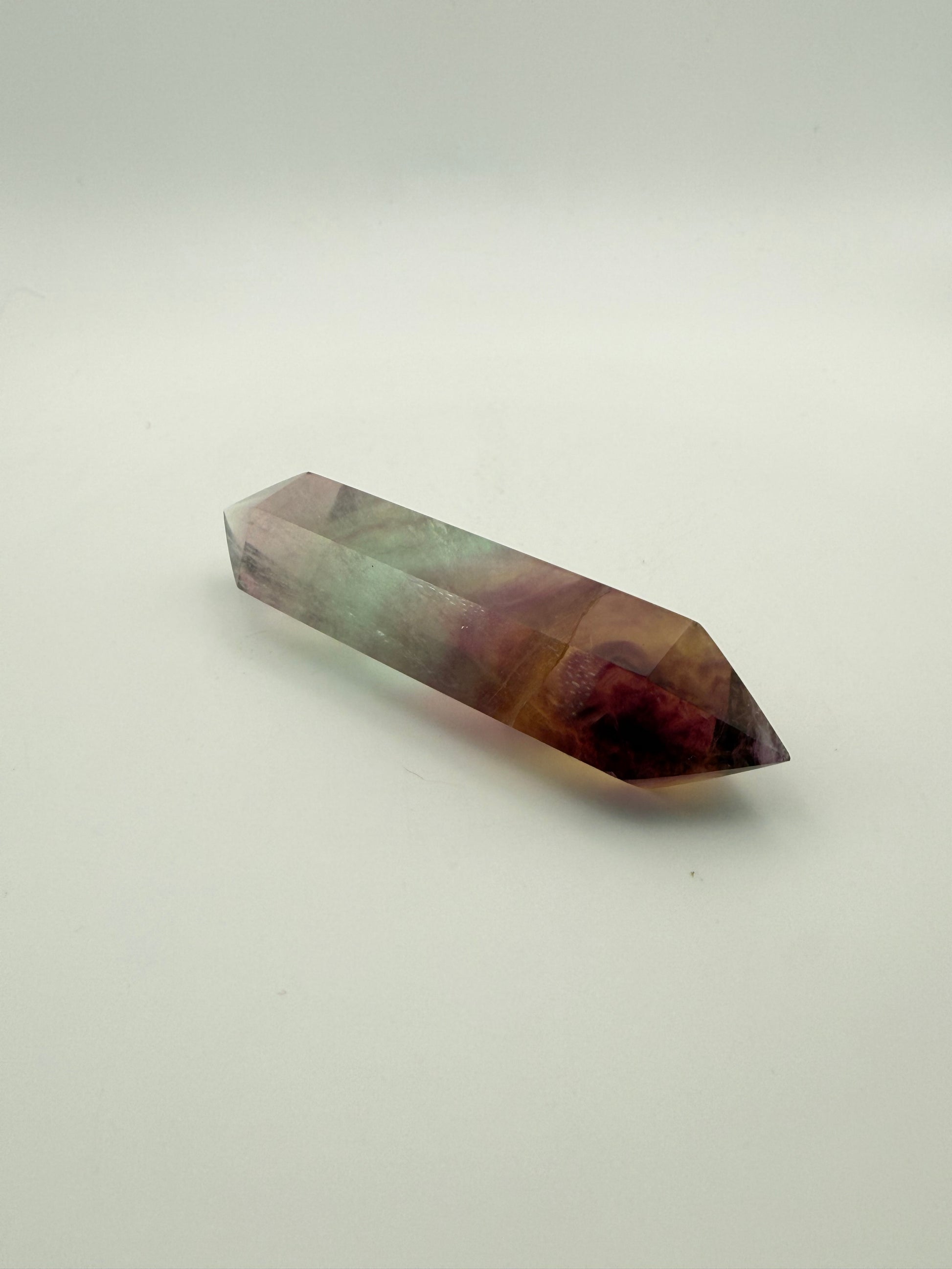 Rainbow Fluorite polished crystal in the shape of a double term.