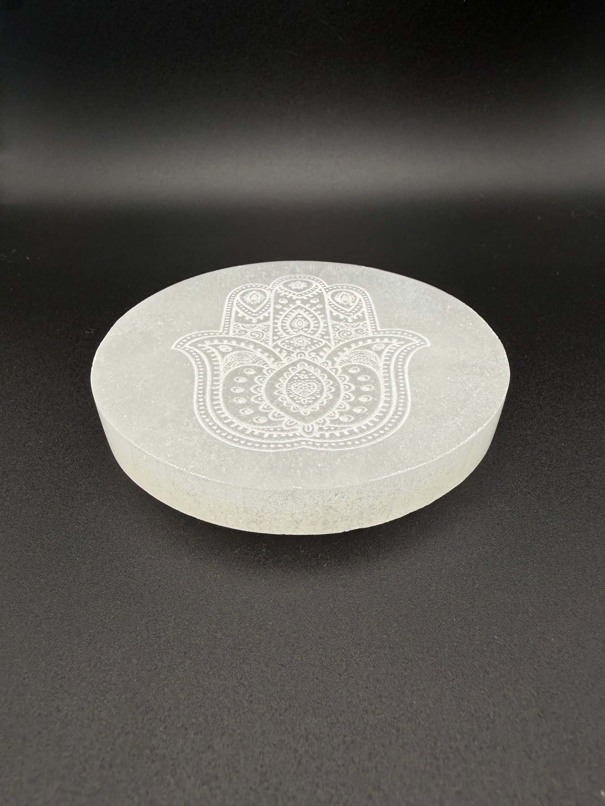 Selenite coaster with engraved hasma hand symbol.