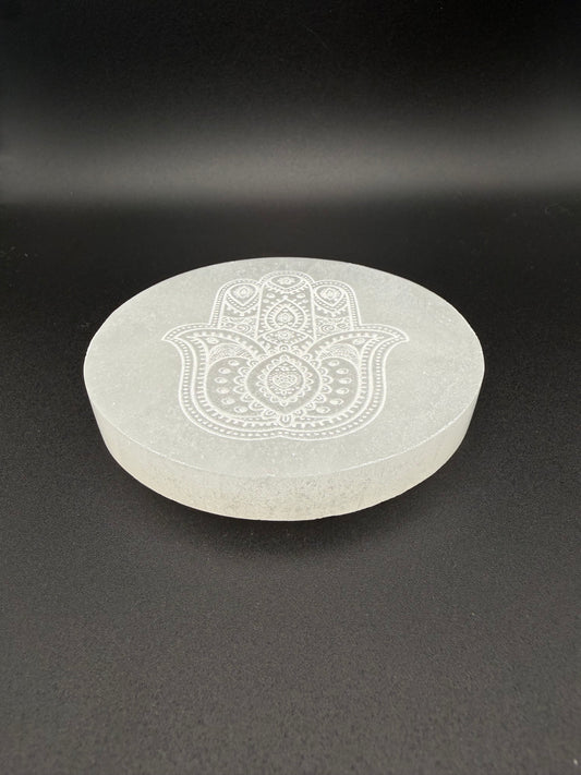 Selenite coaster with engraved hasma hand symbol.