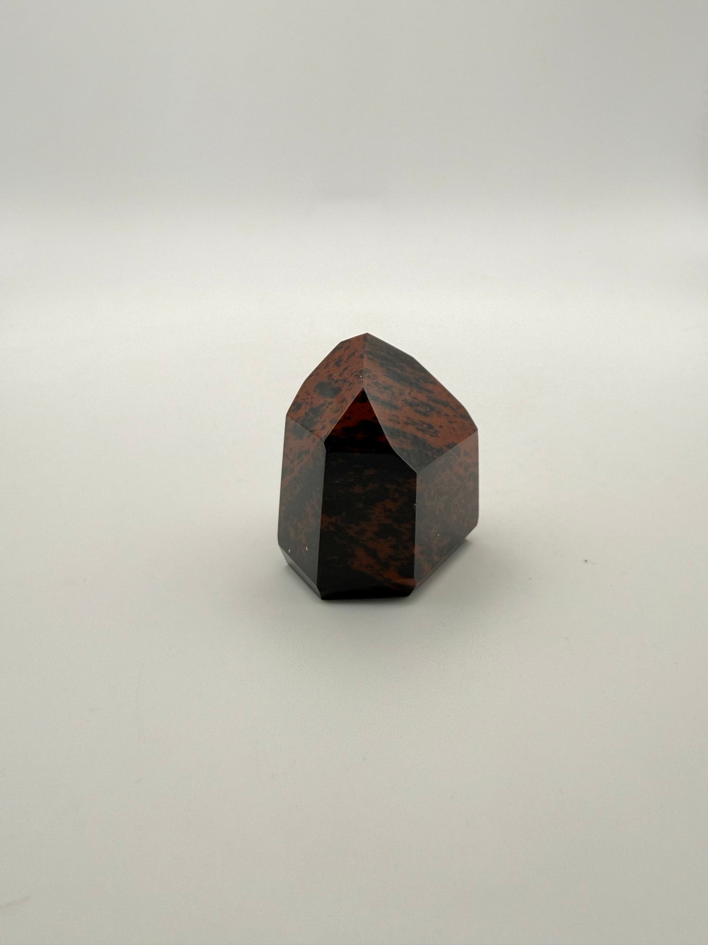 Polished mahogany obsidian tower with six sides.