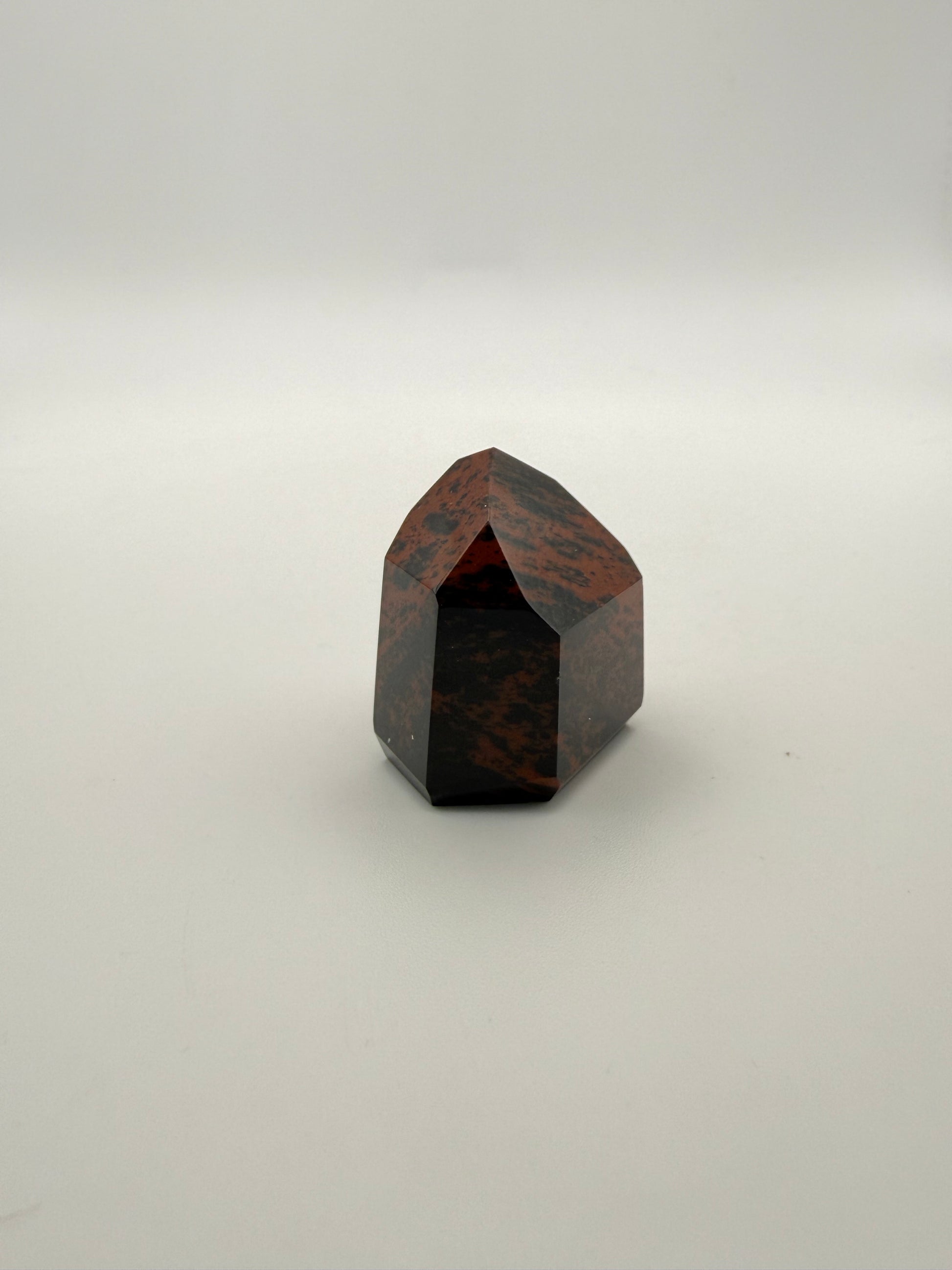 Polished mahogany obsidian tower with six sides.