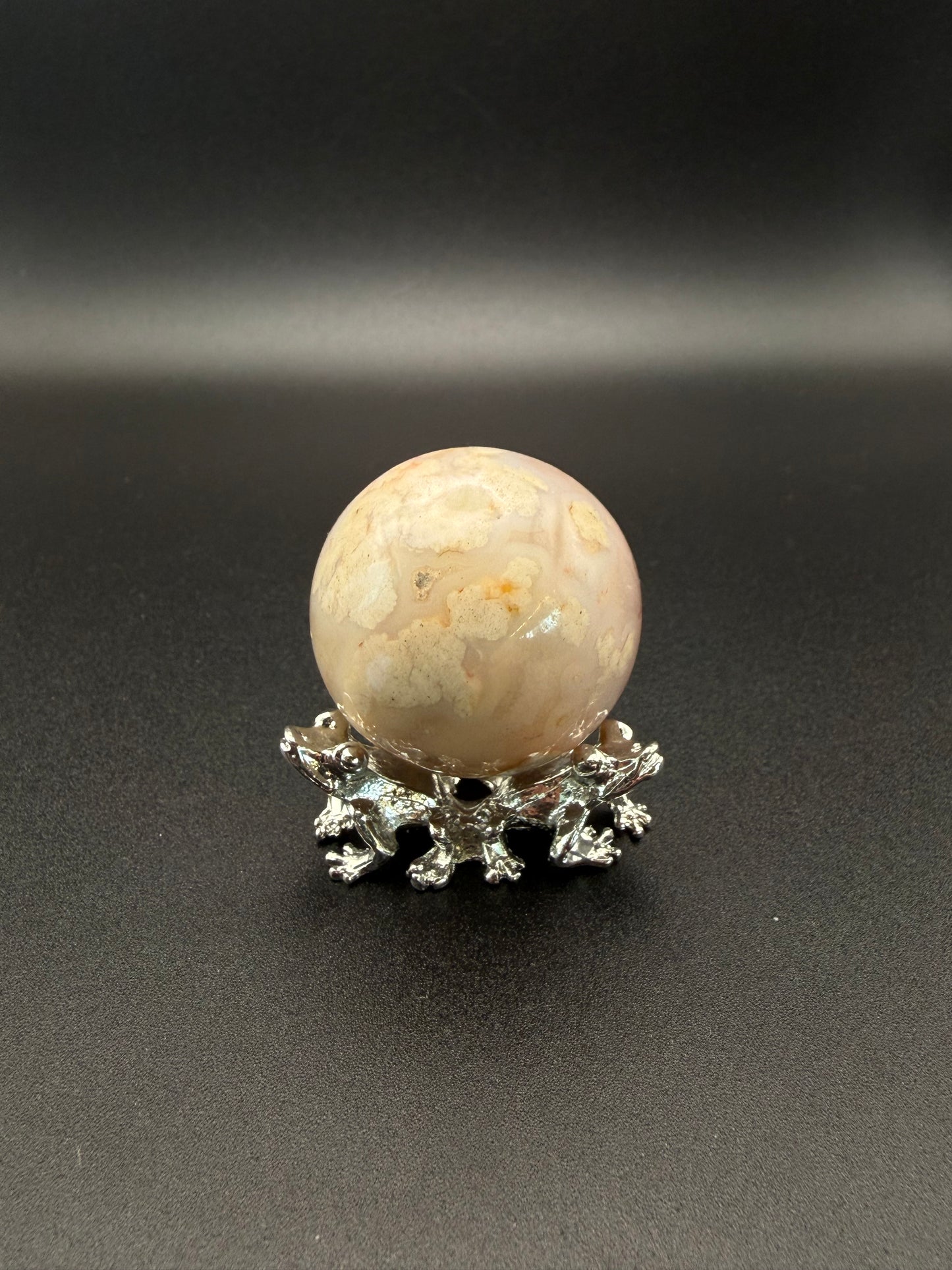 Flower agate polished crystal in the shape of a sphere.