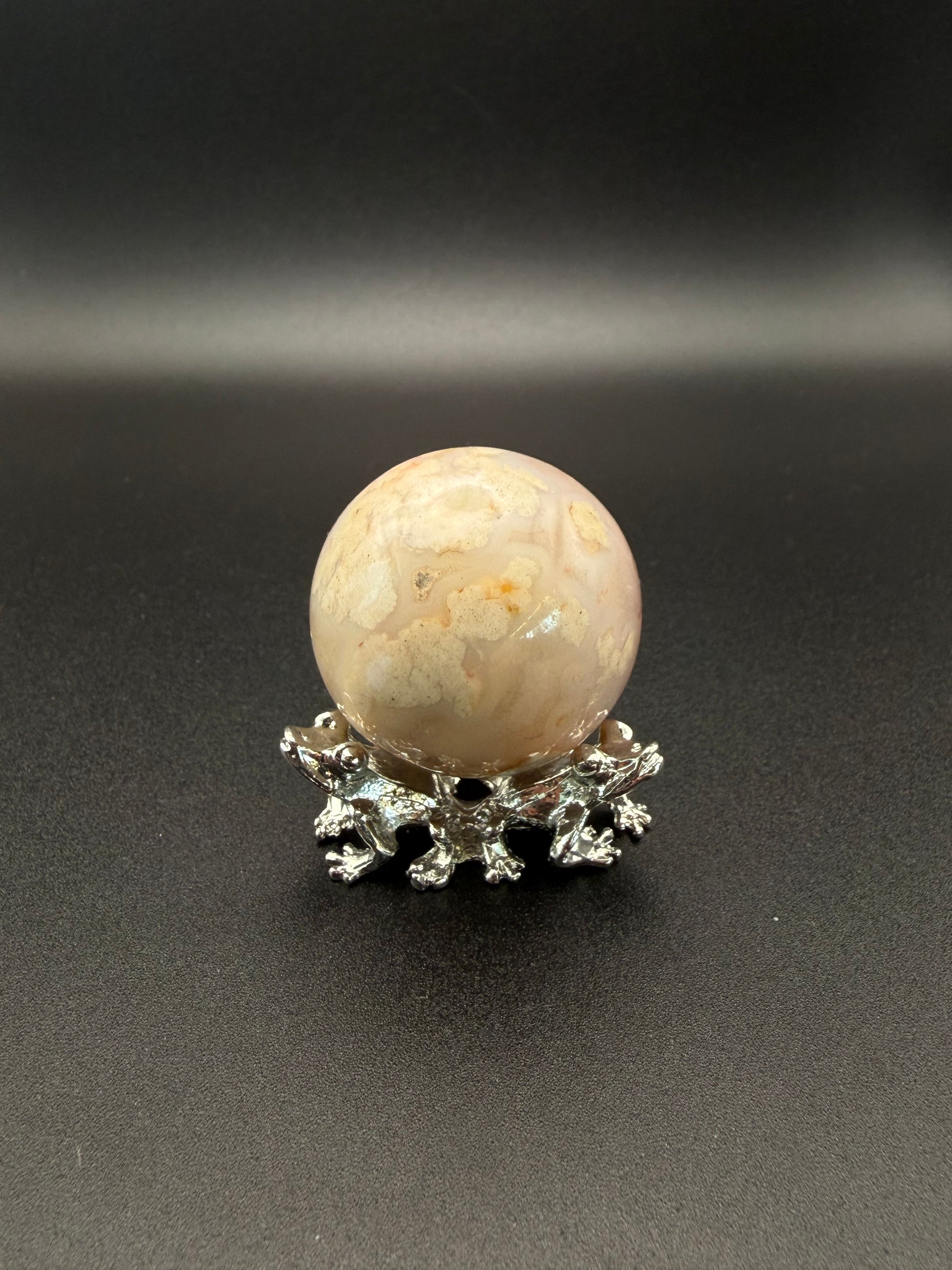 Flower agate polished crystal in the shape of a sphere.