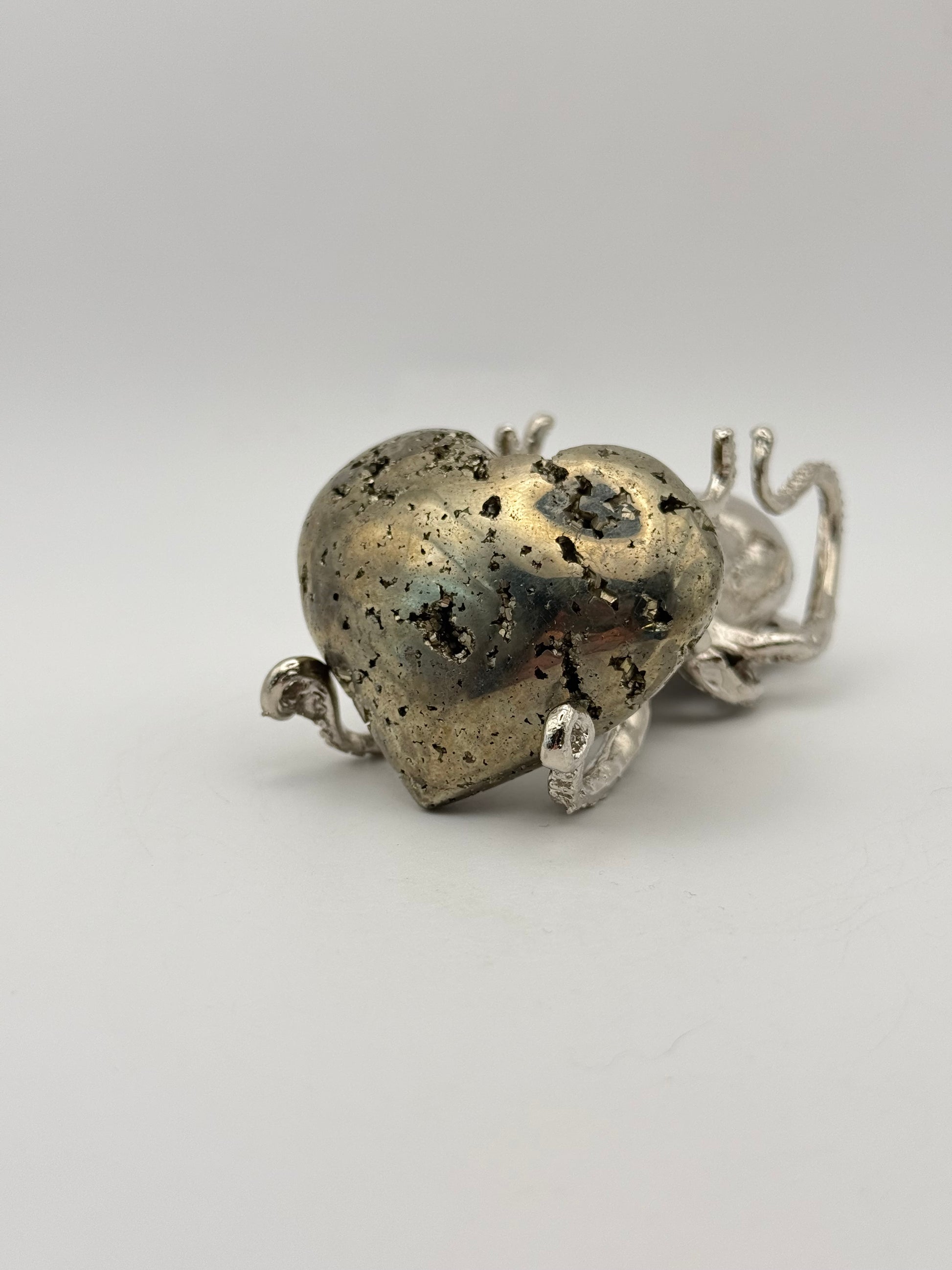 Polished pyrite crystal in the shape of a heart.