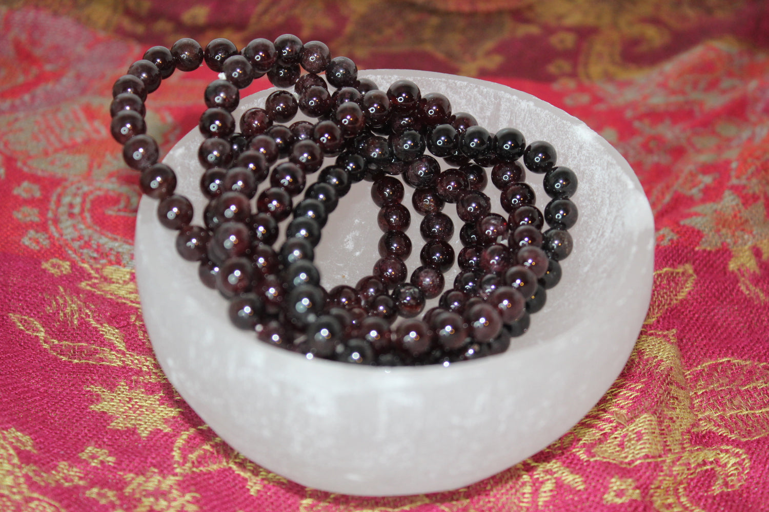 A series of round garnet bead bracelets 8mm in size.